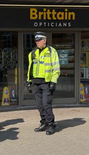 Police officer standing outside Brittain Opticians in Harborne, Birmingham.