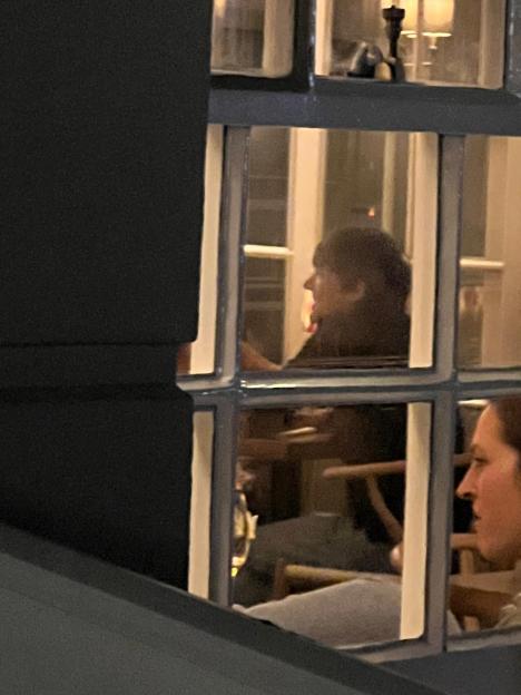 Photo of Zara McDermott and Louis Tomlinson inside a hotel window.