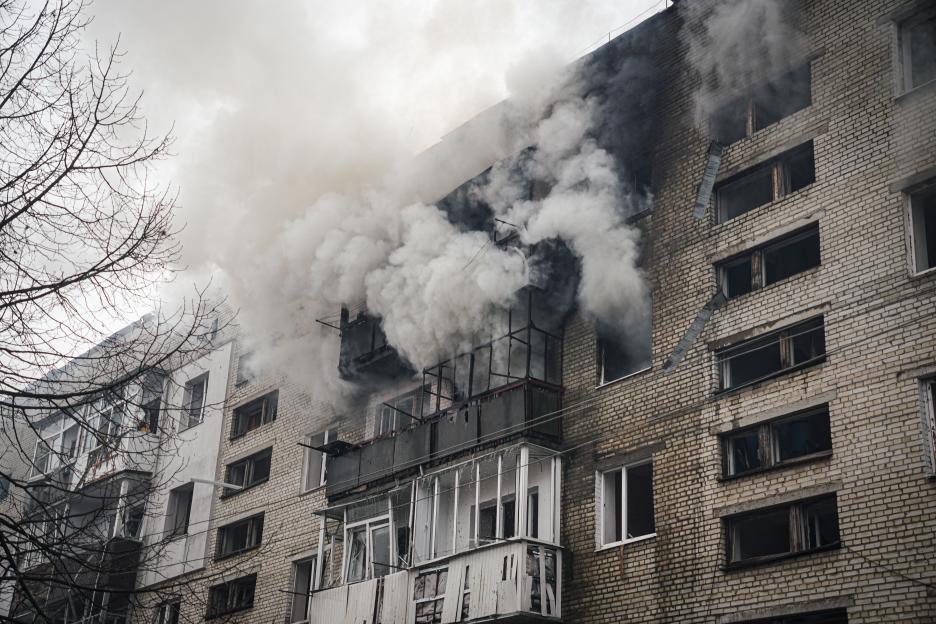 Smoke billows from a damaged residential building.