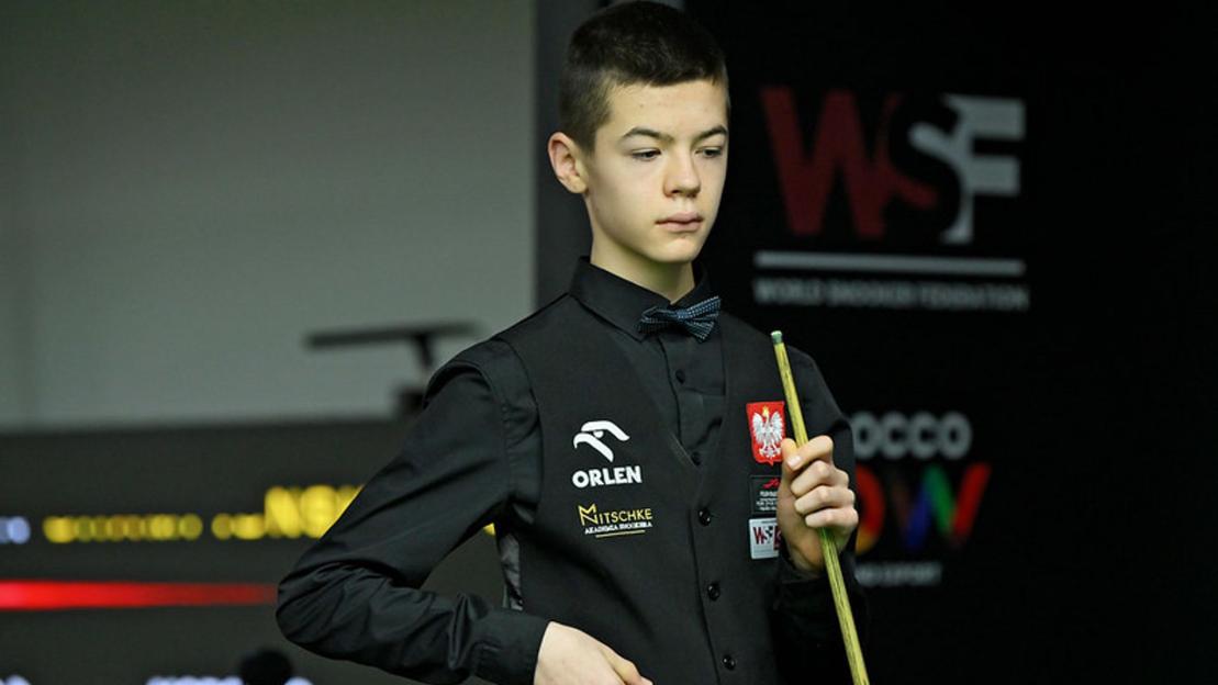 A young snooker player holding a cue.