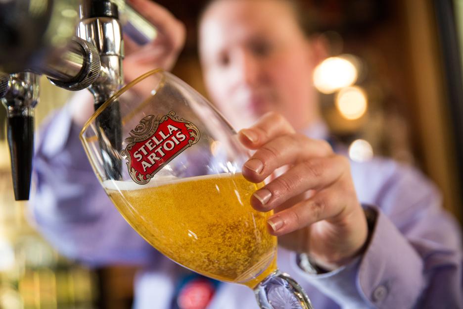 Bartender pouring Stella Artois beer.