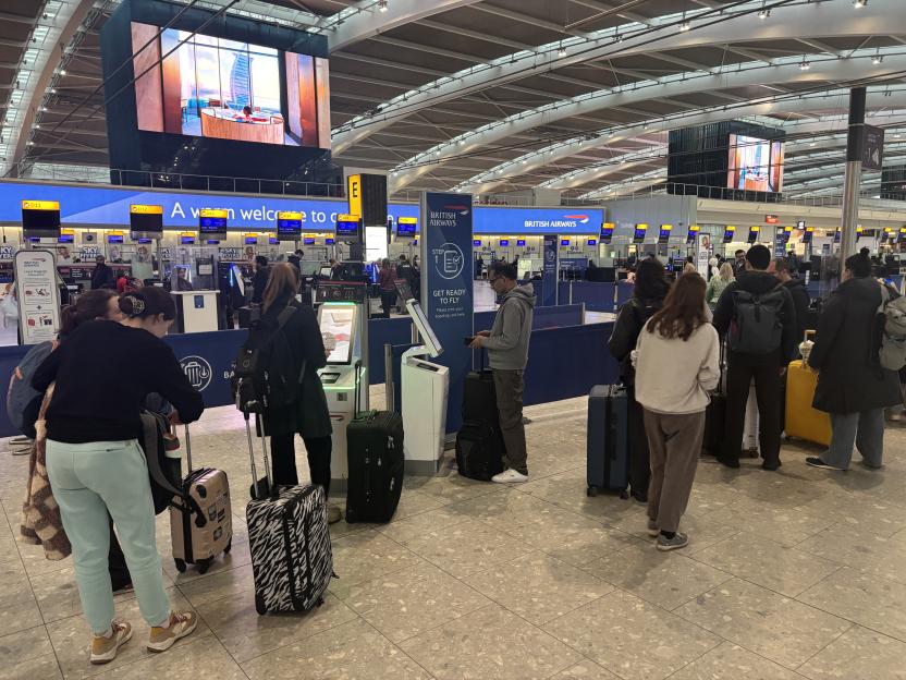 Crowded Heathrow Airport terminal with passengers checking in.