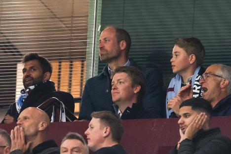 Prince William, Prince George, and others watching a soccer match.