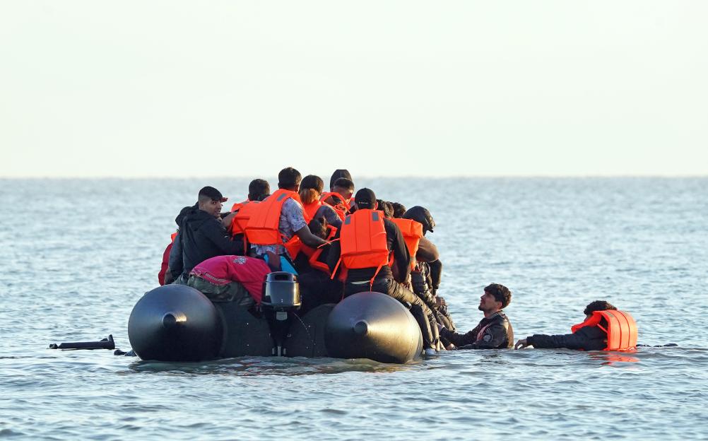 Migrants in a small boat at sea.