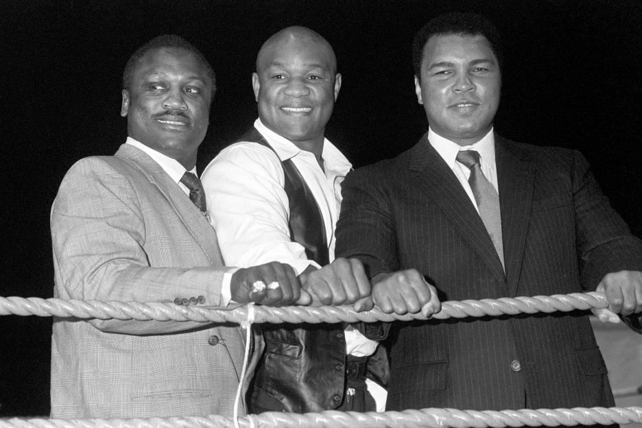 Black and white photo of Joe Frazier, George Foreman, and Muhammad Ali.