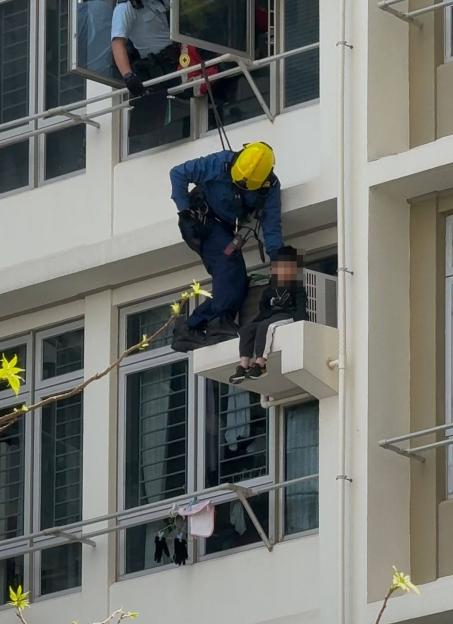 Rescue worker saving a boy from a Hong Kong building.