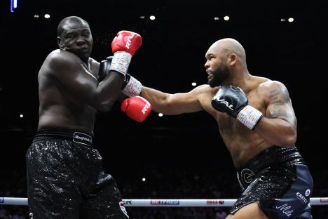Frazer Clarke punches Ebenezer Tetteh during a heavyweight boxing match.